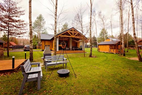 a cabin in a park with a bench and a swing at Winiec Family Houses in Winiec