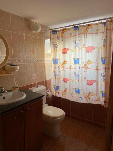 a bathroom with a toilet and a shower curtain at Spiti Damianos Villa Beachfront in Pomos