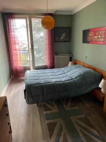 a bedroom with a large bed and a large window at LE CHOUKI in Annecy