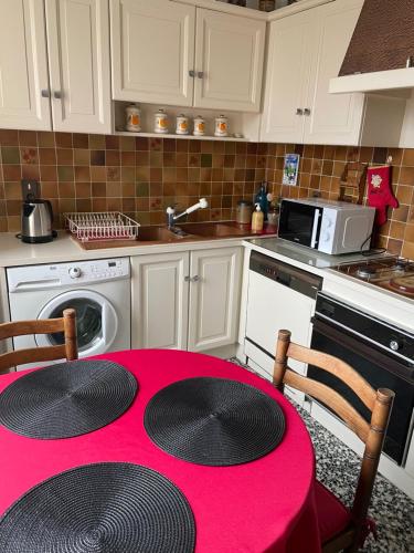 une cuisine avec une table rouge dans l'établissement LE CHOUKI, à Annecy