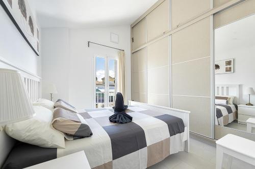 a bedroom with a bed and a large window at Villetta Green oasis club in Maspalomas
