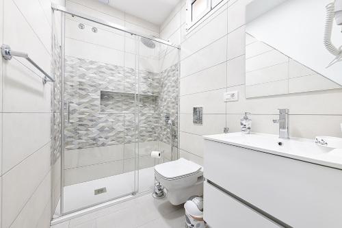 uma casa de banho com um chuveiro, um WC e um lavatório. em Villetta Green oasis club em Maspalomas