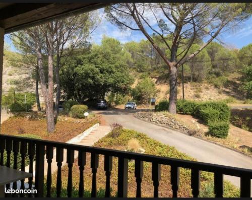 een balkon met uitzicht op een weg en bomen bij Studio lumineux en bordure de verdon in Gréoux-les-Bains