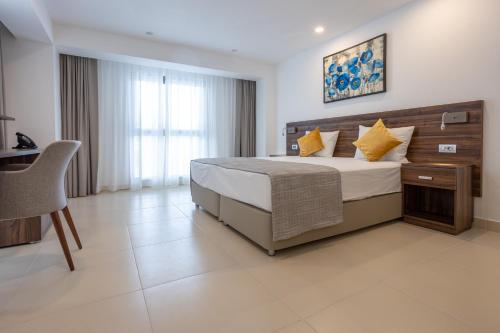 a bedroom with a bed and a chair in it at Hôtel l'Europe in Djibouti