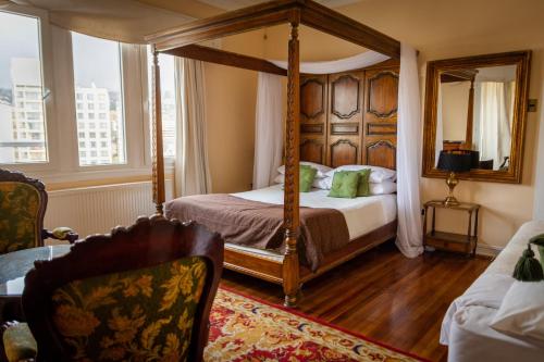 a bedroom with a four poster bed with a mirror at Chocolate Manor House Hotel Boutique in Viña del Mar