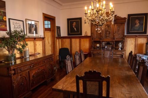 een eetkamer met een tafel en een kroonluchter bij Chocolate Manor House Hotel Boutique in Viña del Mar