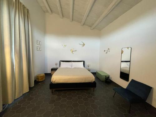 1 dormitorio con 1 cama y 1 silla en Chiusa del Curiale - ospitalità in vigna, en Comiso