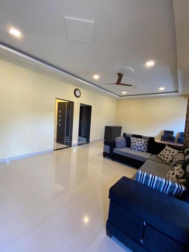 a living room with couches and a clock on the ceiling at Aroma Residency 2bhk villa & delux rooms in Mahabaleshwar