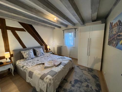 Un dormitorio con una cama en una habitación con techos de madera. en Colombages de la Lauch, en Colmar