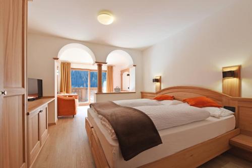 una camera con un grande letto e una televisione di Hotel Brunello a Ortisei