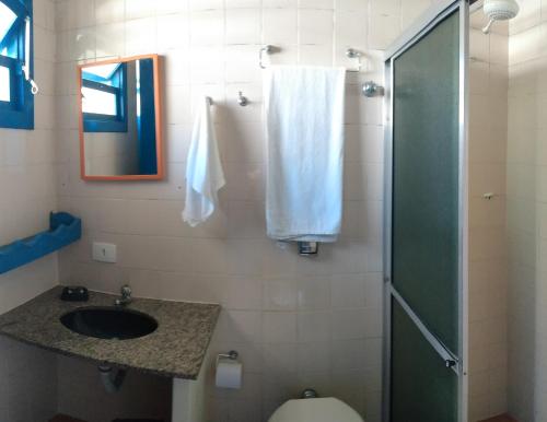 a bathroom with a sink and a shower and a toilet at Pousada Canoeiro in Ubatuba