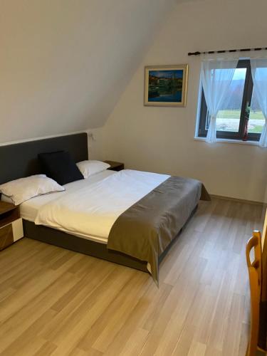 a bedroom with a large bed and a wooden floor at Antemurale - Luxury rooms,Plitvice Lakes in Rastovača