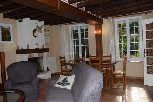 un salon avec un canapé et une cheminée dans l'établissement La ferme des Cailloux, à Sassay