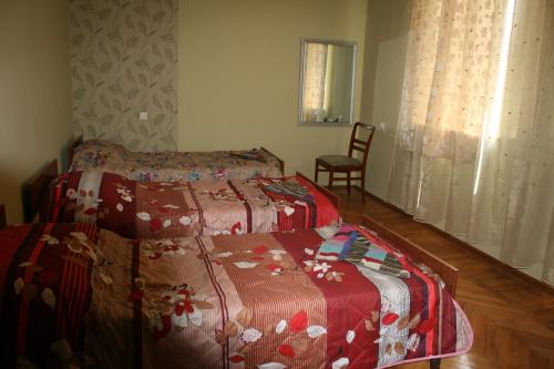 a bedroom with two beds and a chair at Guest House Lviv Грузия in Kutaisi