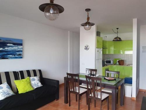 ein Wohnzimmer mit Tisch und Couch in der Unterkunft Apartamento El Coral in Famara