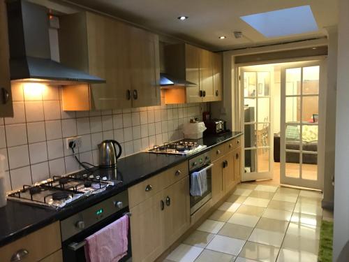 a kitchen with wooden cabinets and black counter tops at Atlas Oxford House in Oxford