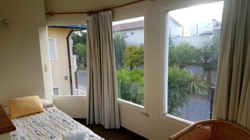 un dormitorio con cama y una gran ventana en Hostería Esturion Village en Villa Gesell