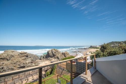 a balcony with a view of the beach at Picnic Rock Seaside Accommodation in Keurboomstrand