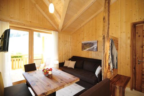 a living room with a couch and a wooden table at Hotel Naturoase Schwemmerhof in Ultimo