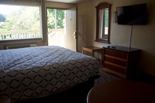 a bedroom with a bed and a window and a dresser at Express INN in Norfolk