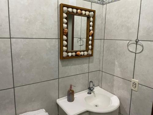 a bathroom with a sink and a mirror at Pousada Elementais do Rosa in Praia do Rosa