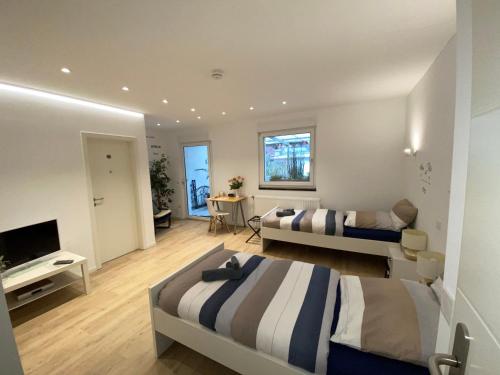 una camera d'albergo con due letti e una televisione di Home-Rose-Garden-Gästehaus kontaktloser Zugang a Dusseldorf