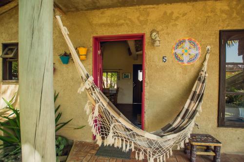 a hanging hammock outside of a house at Pousada Gopak in Praia do Rosa