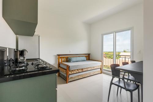 a kitchen with a bed and a kitchen with a stove at Parador Campeche in Florianópolis