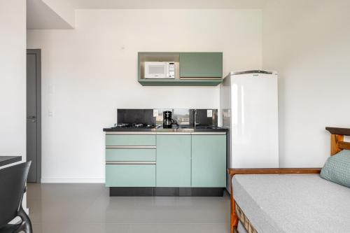 a small kitchen with a sink and a refrigerator at Parador Campeche in Florianópolis