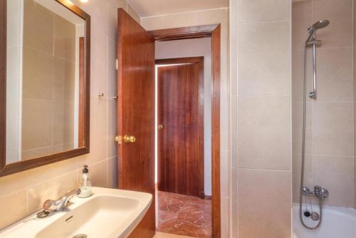 a bathroom with a sink and a shower with a mirror at Las Antillas, Carvajal in Fuengirola