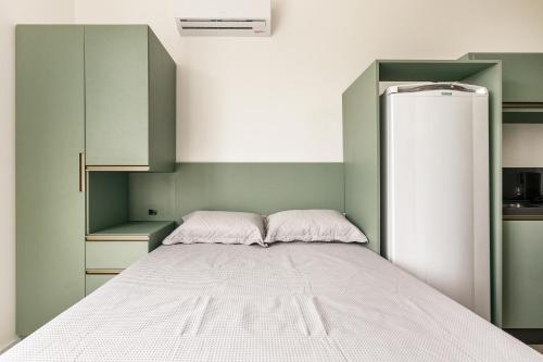 a bedroom with a bed and a refrigerator at Parador Campeche in Florianópolis