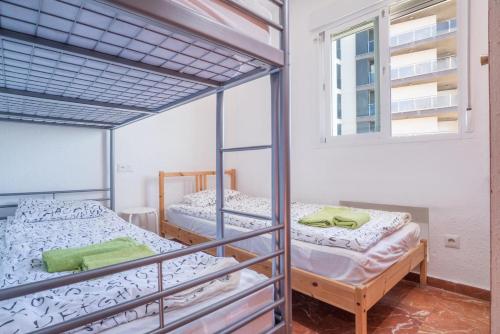 two bunk beds in a room with a window at Las Antillas, Carvajal in Fuengirola