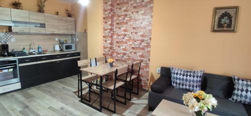 een keuken en een woonkamer met een tafel en een bank bij Апартамент Туида in Sliven