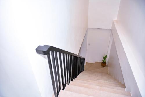 a staircase with white walls and a black rail at Hotel Don Raul in Dagupan