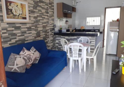 uma sala de estar com um sofá azul e uma mesa e cadeiras em Casa Serena Jacumã em Jacumã