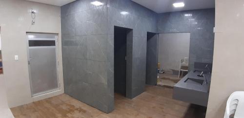 ein Bad mit einer grauen Wand und einem Waschbecken in der Unterkunft Cavalinho Branco Apart-Hotel 11D in Águas de Lindóia