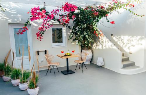 a patio with flowers and a table and chairs at Edem Boutique Suites in Oia