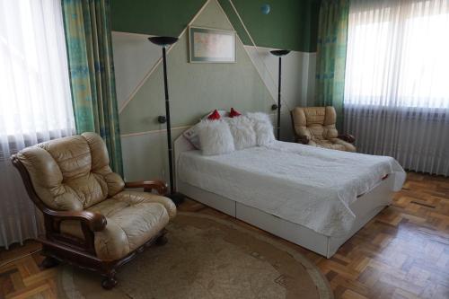 a bedroom with a bed and a chair at Home for Guests Lakštingala in Šiauliai