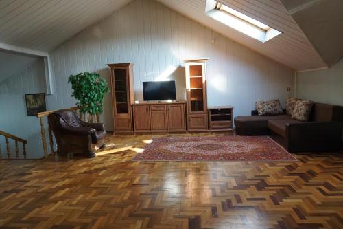 a living room with a couch and a flat screen tv at Home for Guests Lakštingala in Šiauliai