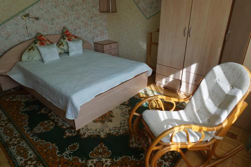 a bedroom with a bed and a chair at Home for Guests Lakštingala in Šiauliai