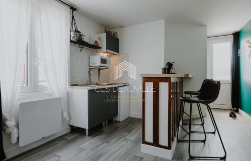 a kitchen with a counter and a chair in a room at La Deauvillaise CLS Deauville in Deauville