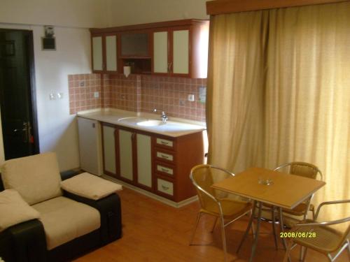 a small kitchen with a sink and a table and chairs at Times Apart in Çeşme