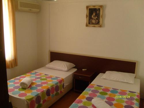 a bedroom with two beds and a picture on the wall at Times Apart in Çeşme