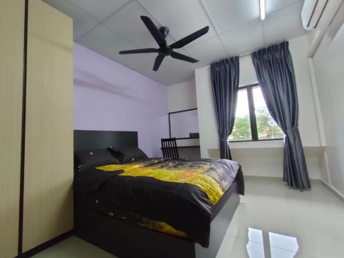 una camera con letto e ventilatore a soffitto di SENGGARANG HOMESTAY a Parit Kadir