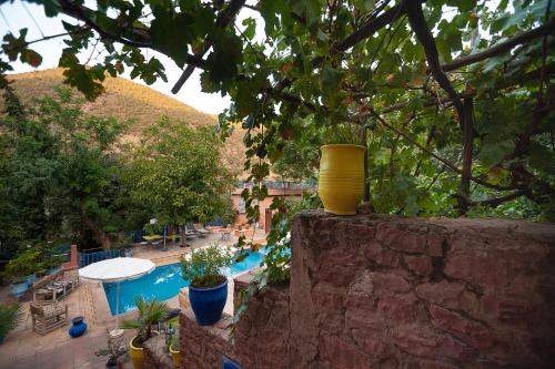 a yellow vase sitting on a wall next to a pool at Auberge le Maquis in Aghbalou