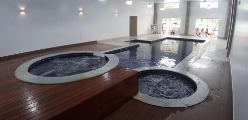 two hot tubs in the middle of a building at Flat-Hotel Cavalinho Branco (G08) in Águas de Lindóia