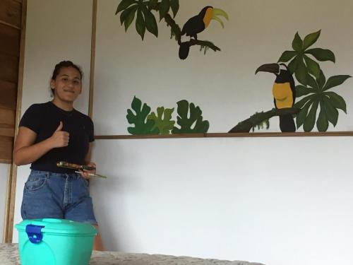 a man standing in front of a wall with a painting at Bella Vista Ranch Ecolodge in Turrialba