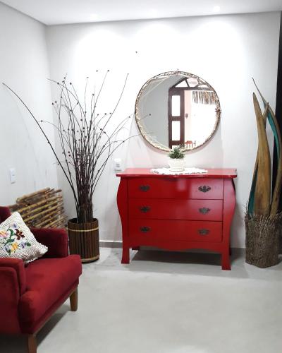 Vestidor rojo con espejo y silla roja en Pousada Alto Caparaó, en Caparaó Velho