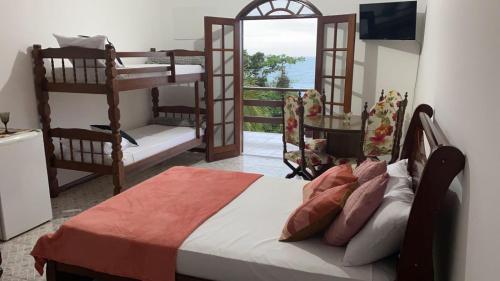 a bedroom with two bunk beds and a balcony at Praia Virgem Hostel in Rio das Ostras