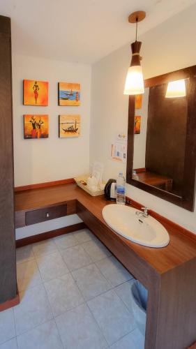 a bathroom with a sink and a mirror at Golden Bay Cottage - SHA Extra Plus in Ko Lanta